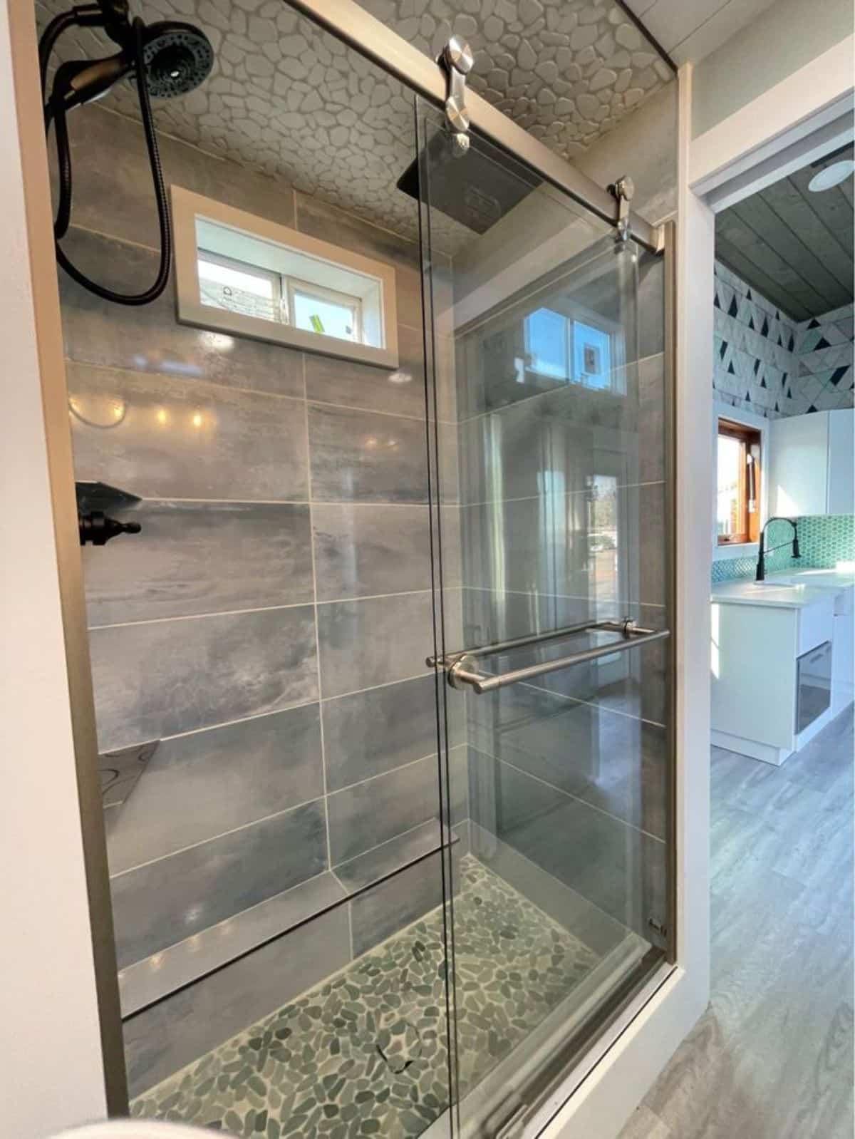 full tiled with glass sliding door of shower area in bathroom