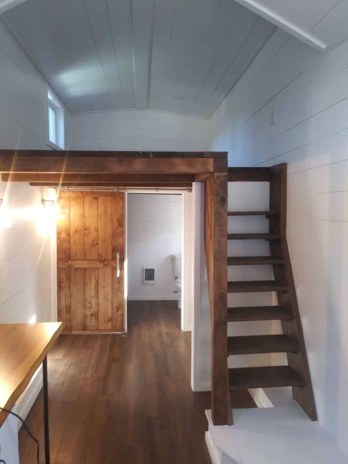 beautifully designed stairs leading to the loft bedroom of tiny getaway cabin