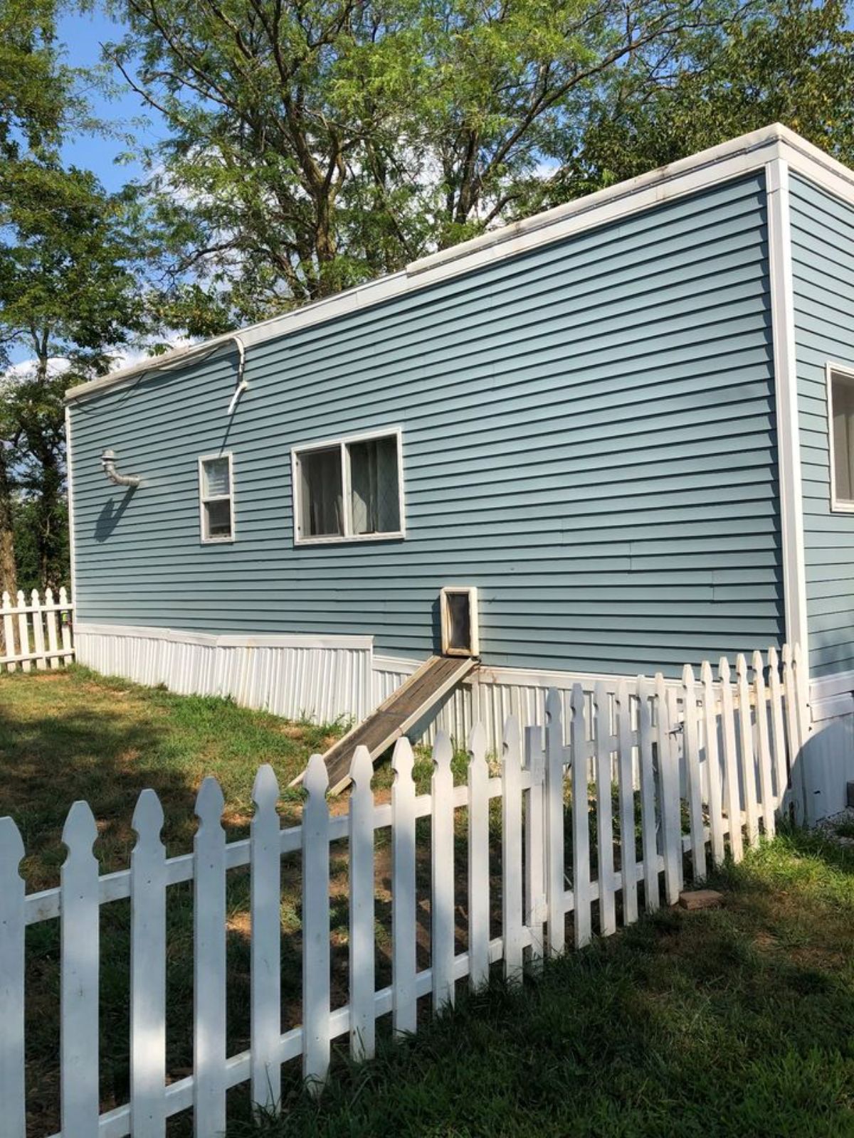 backside of fully furnished tiny home has a small garden type place to enjoy with kids or pets