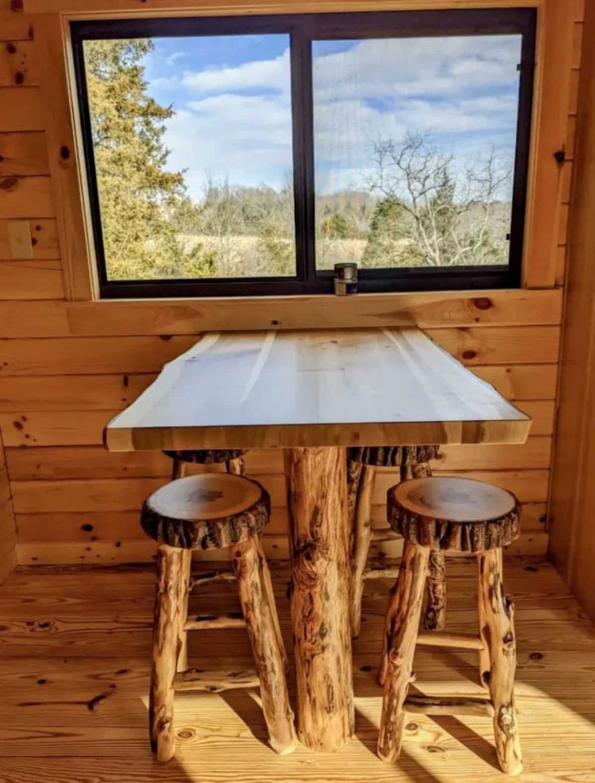 dining area with 4 stools right besides the window