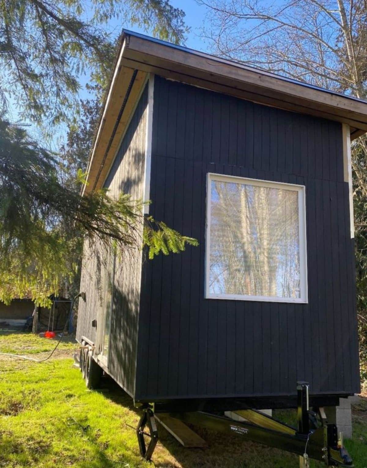 side view of Scandinavian inspired tiny home has a huge window
