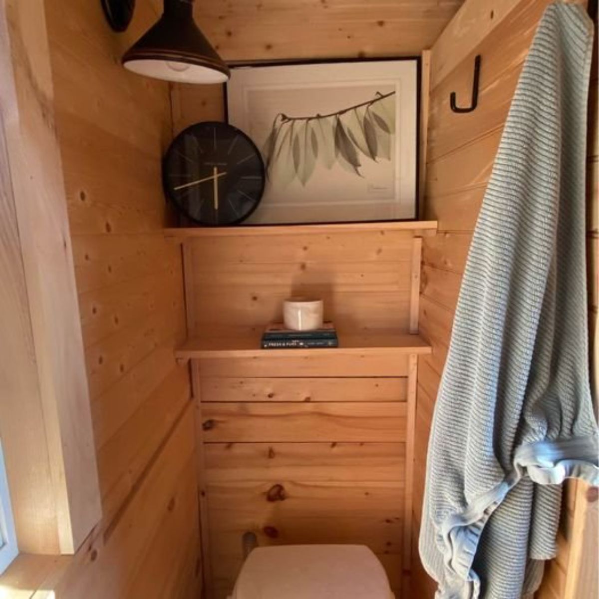 composting toilet with open shelves is installed in bathroom of spacious 2 bedroom tiny home