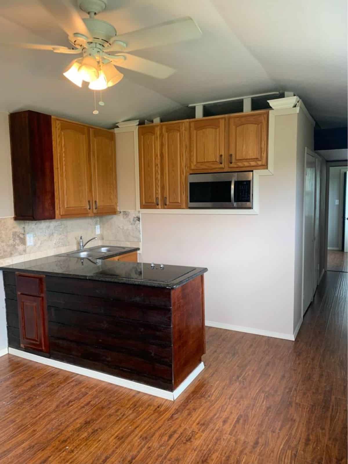 L shaped kitchen countertop in kitchen area with all the appliances and storage cabinets