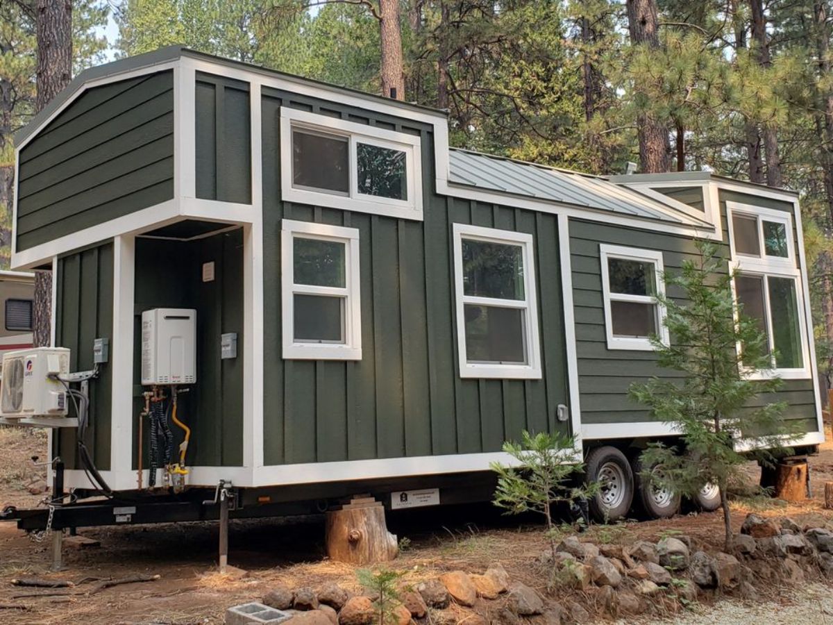 stunning green exterior of stunning 28’ tiny house from behind