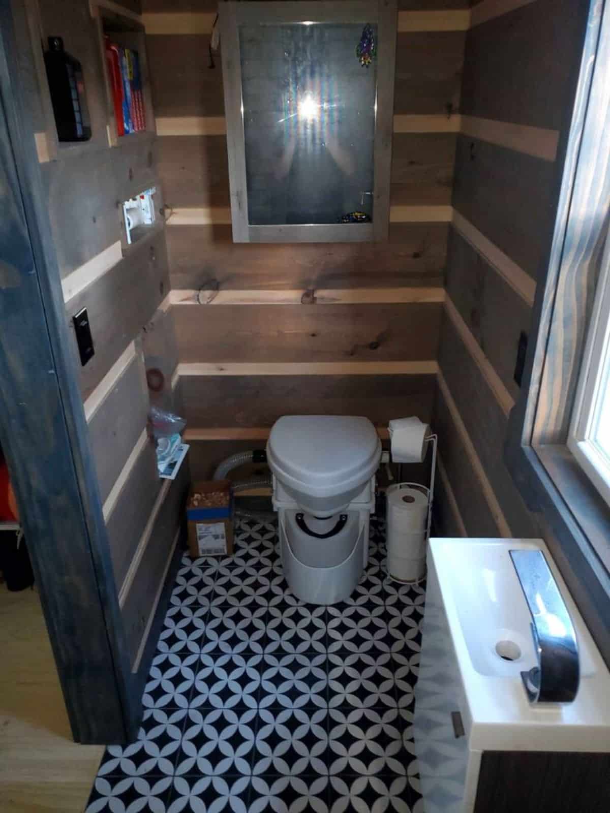 composting toilet, sink with vanity in bathroom of offgrid tiny home