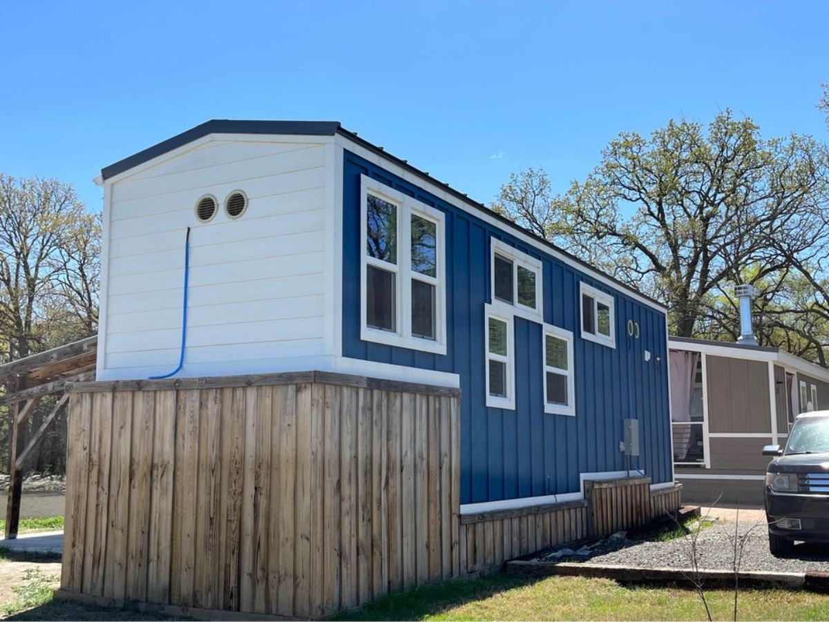 backside of tiny home for four has a blue walls and huge windows