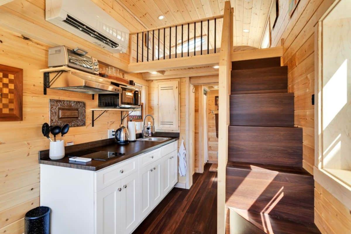 kitchen area of Tumbleweed tiny house has a huge countertop with storage cabinets