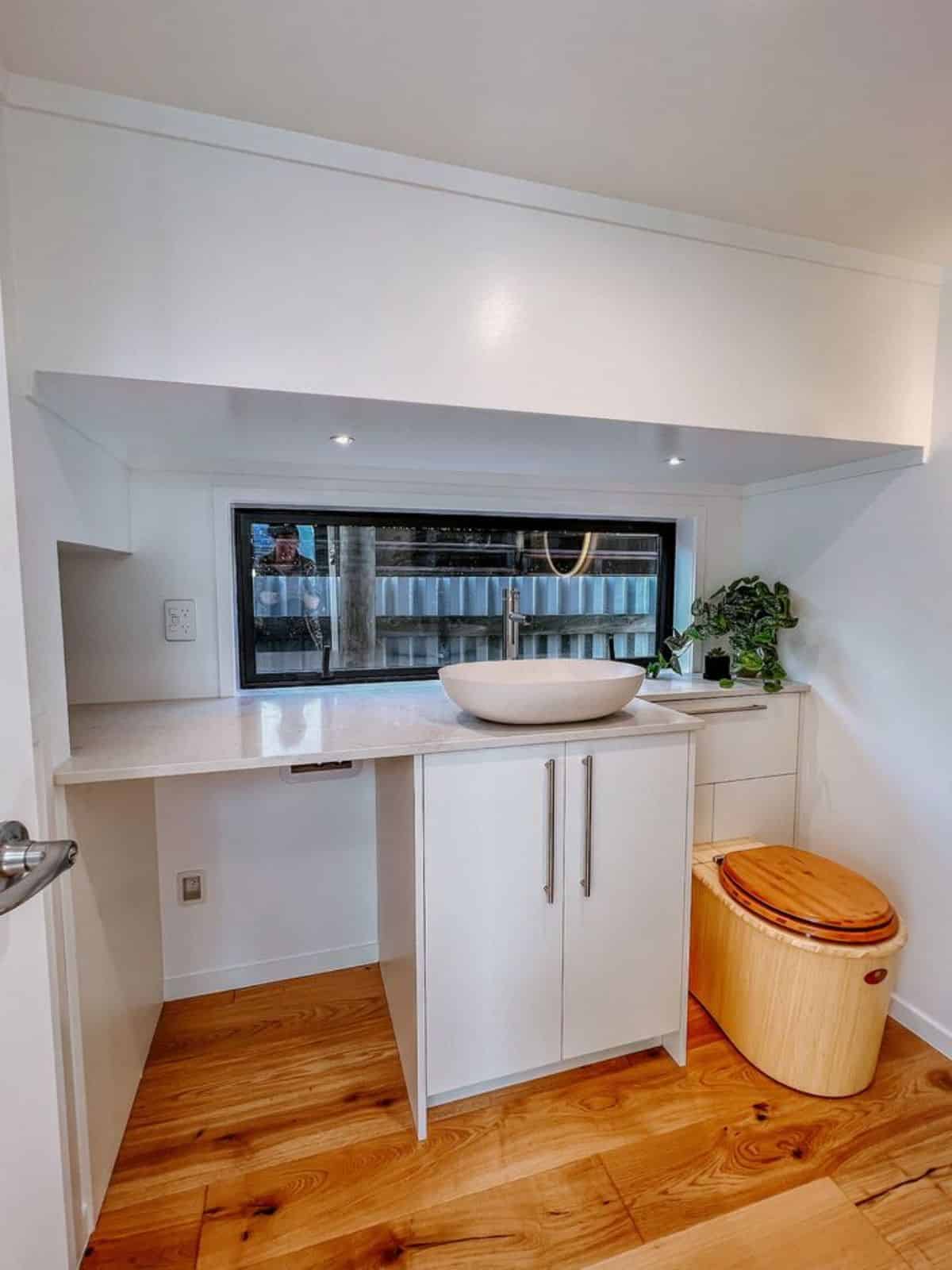 bathroom of 2 bedroom tiny house is stunning with standard toilet, sink with vanity