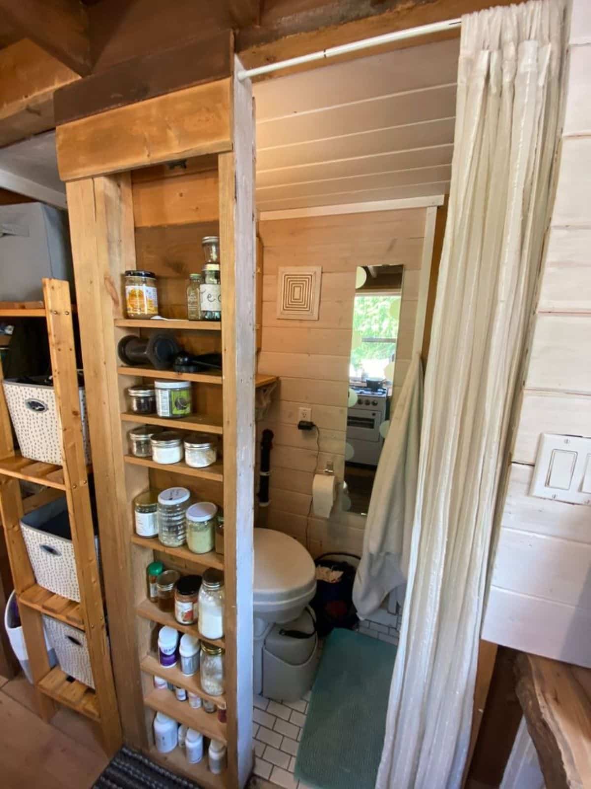 bathroom of 20’ cozy tiny home has all the standard fittings plus pantry storage cabinet outside