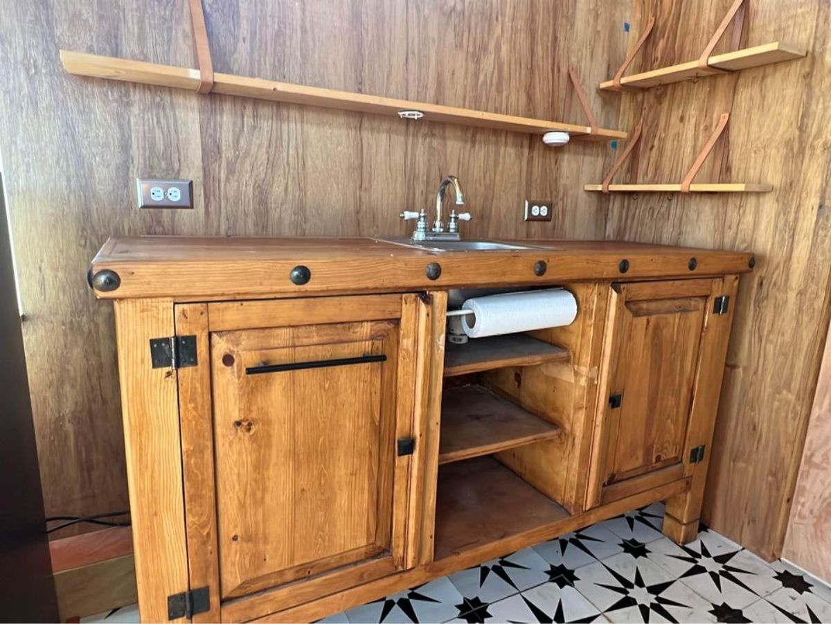 kitchen countertop with storage and racks in kitchen area of insulated tiny home
