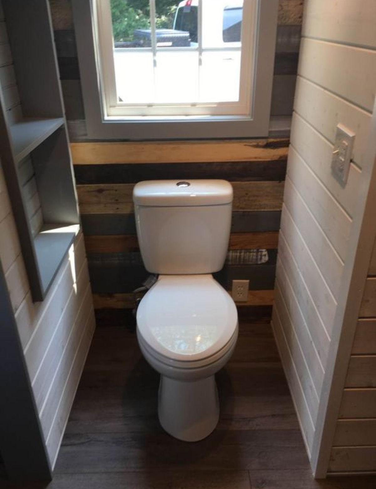 standard toilet in the bathroom of 24' two bed tiny house