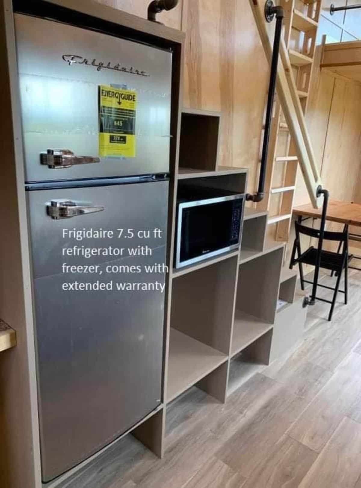 double door refrigerator and microwave oven under the multi purpose stairs of handcrafted tiny home