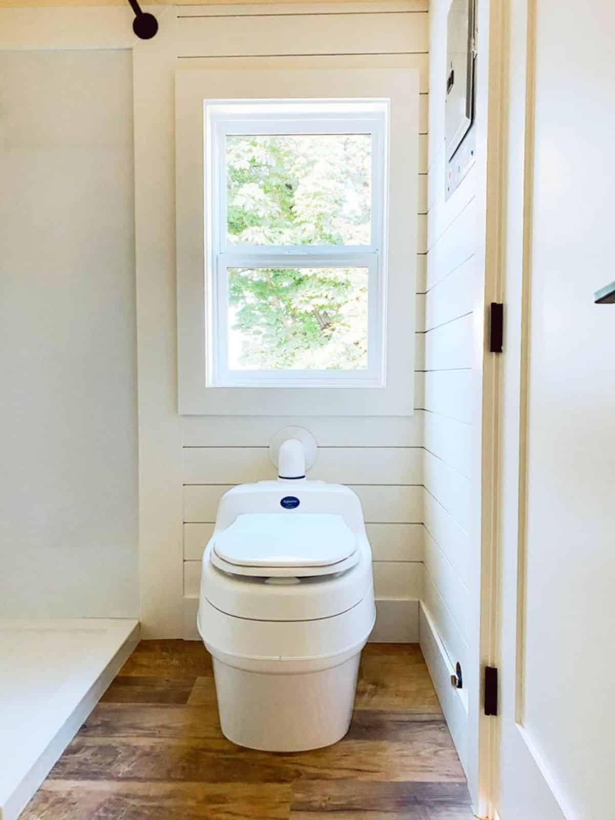 standard toilet in the bathroom of 26' minimalistic tiny home