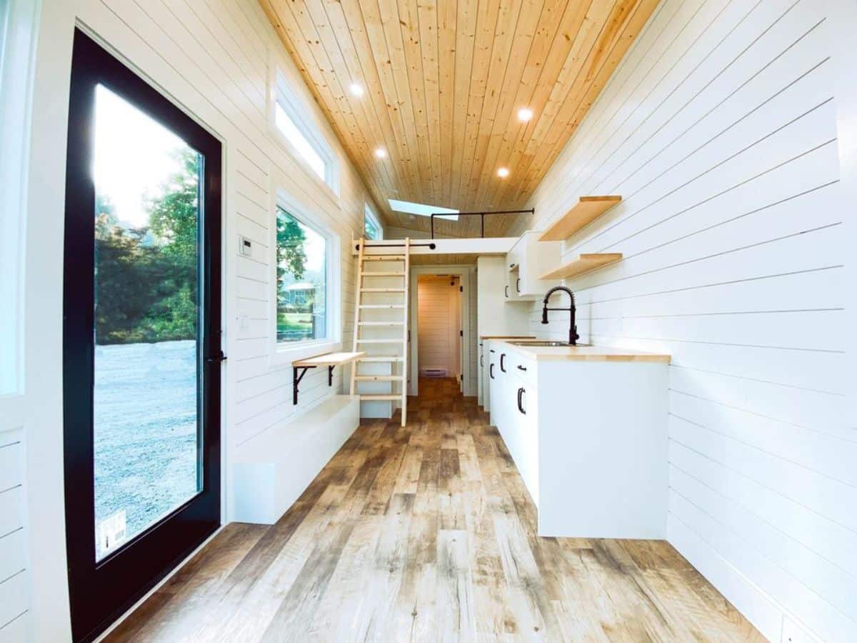 full length interiors with white walls, wooden flooring of 26' minimalistic tiny home