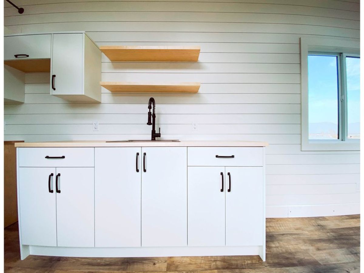 white kitchen area of 26' minimalistic tiny home