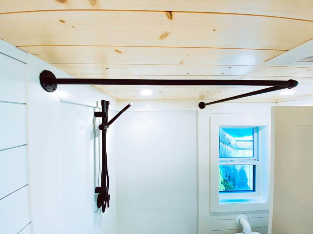 bathroom of 26' minimalistic tiny home has a head rain shower