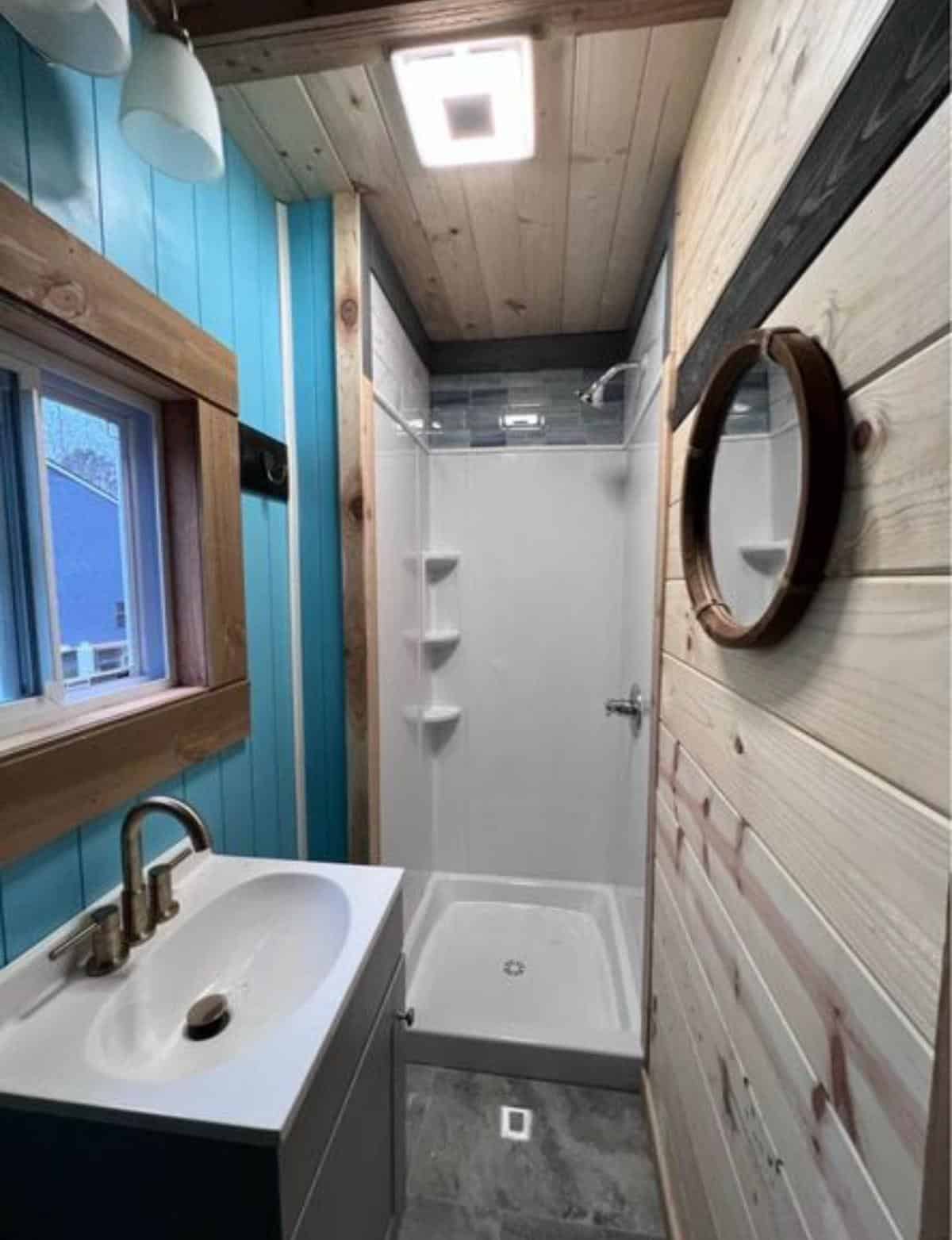 separate full length shower area and sink with vanity & mirror in bathroom of one bed one bath home