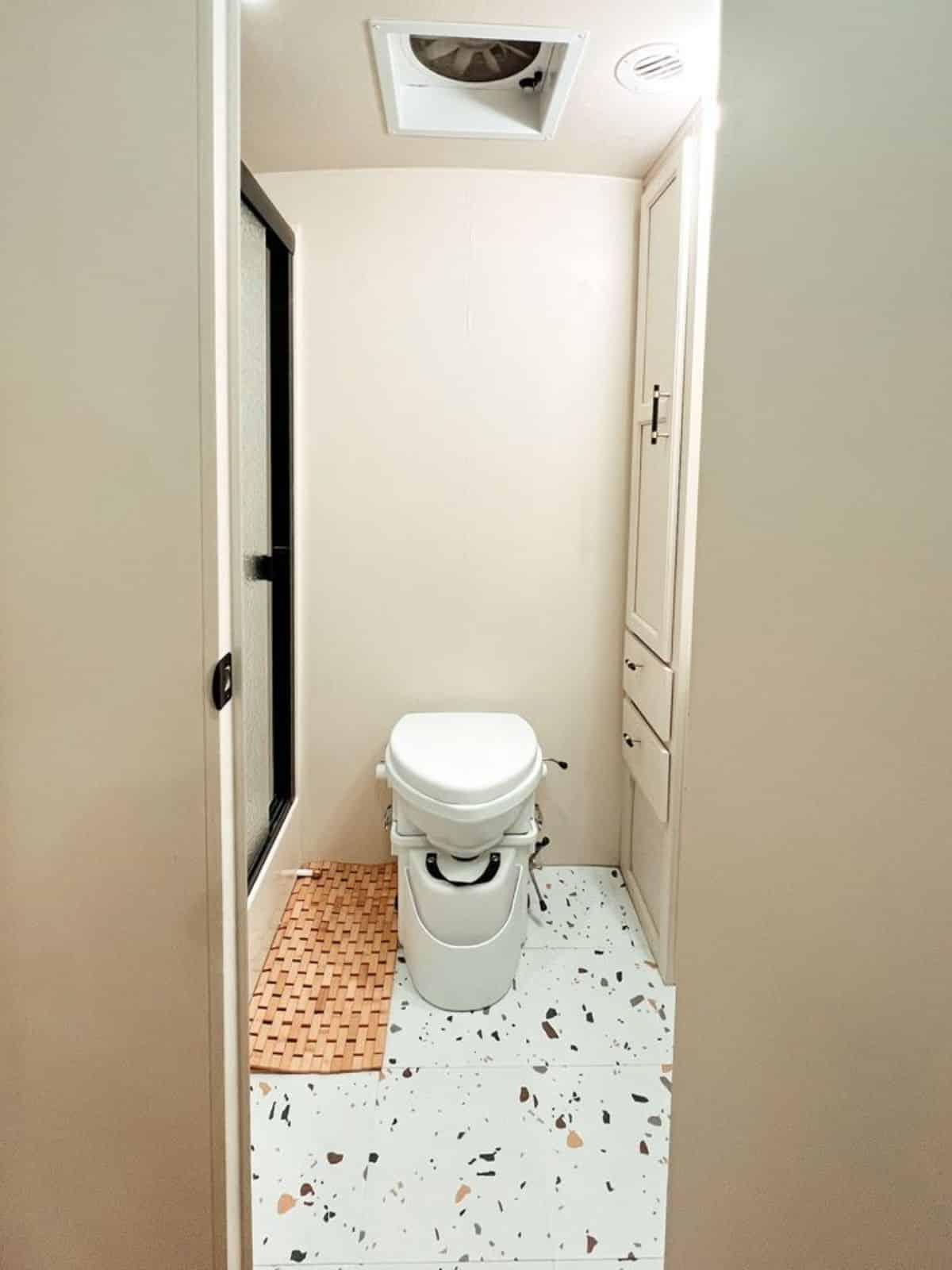 composting toilet  and walk in shower in bathroom