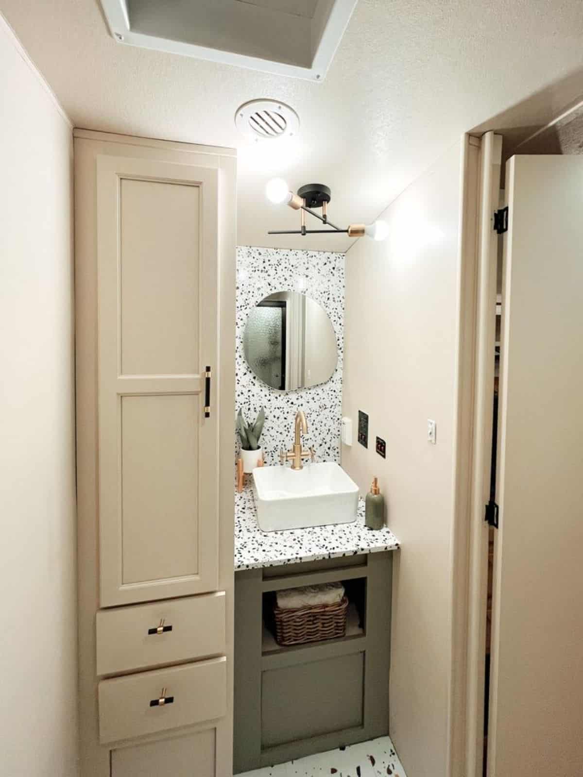 sink with vanity and mirror in the bathroom of redesigned tiny home