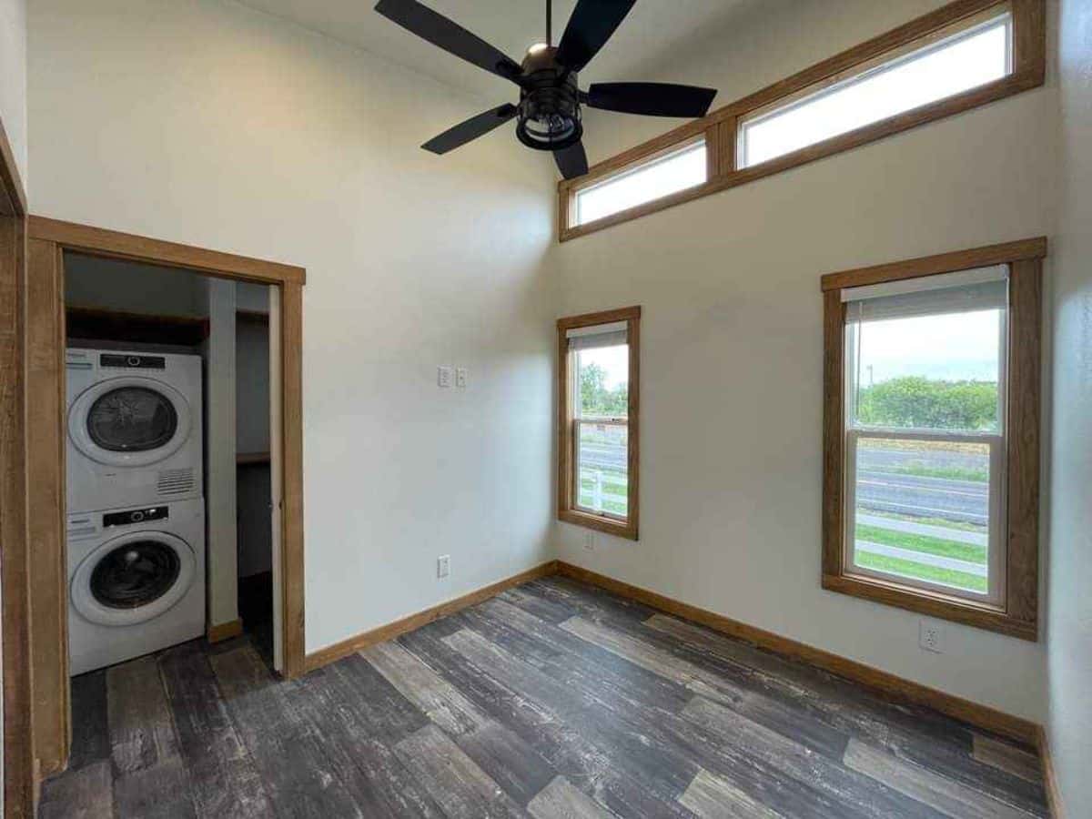 bedroom of cottage tiny home is huge with multiple windows