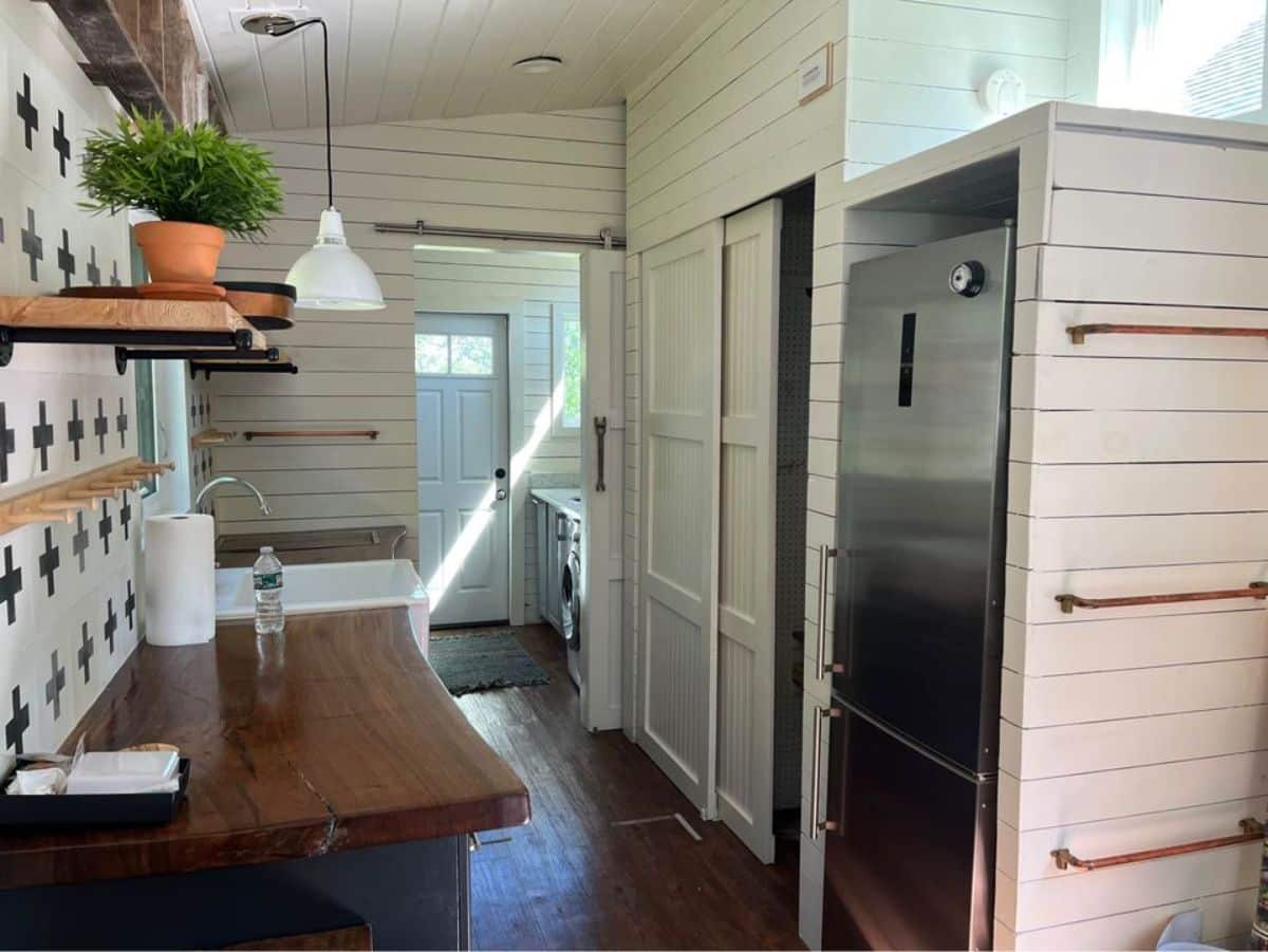 full length double door refrigerator in kitchen area of 35’ tiny house included in the deal