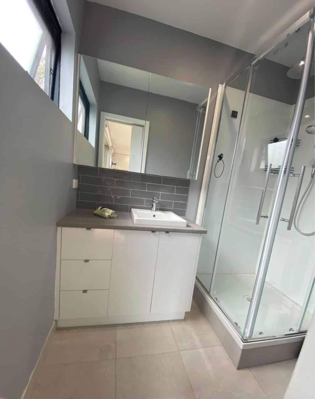 huge sink with vanity and full length shower with glass enclosure