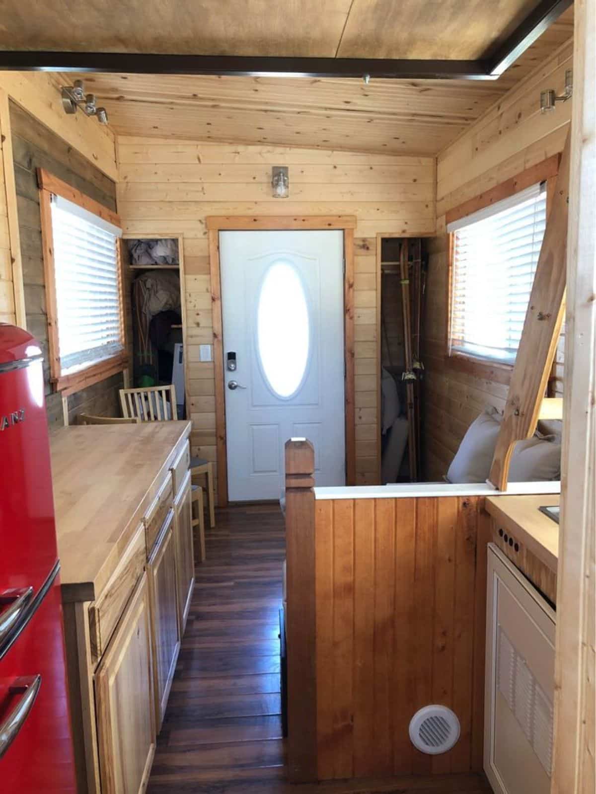 full length wooden interiors of professionally designed tiny home from kitchen view