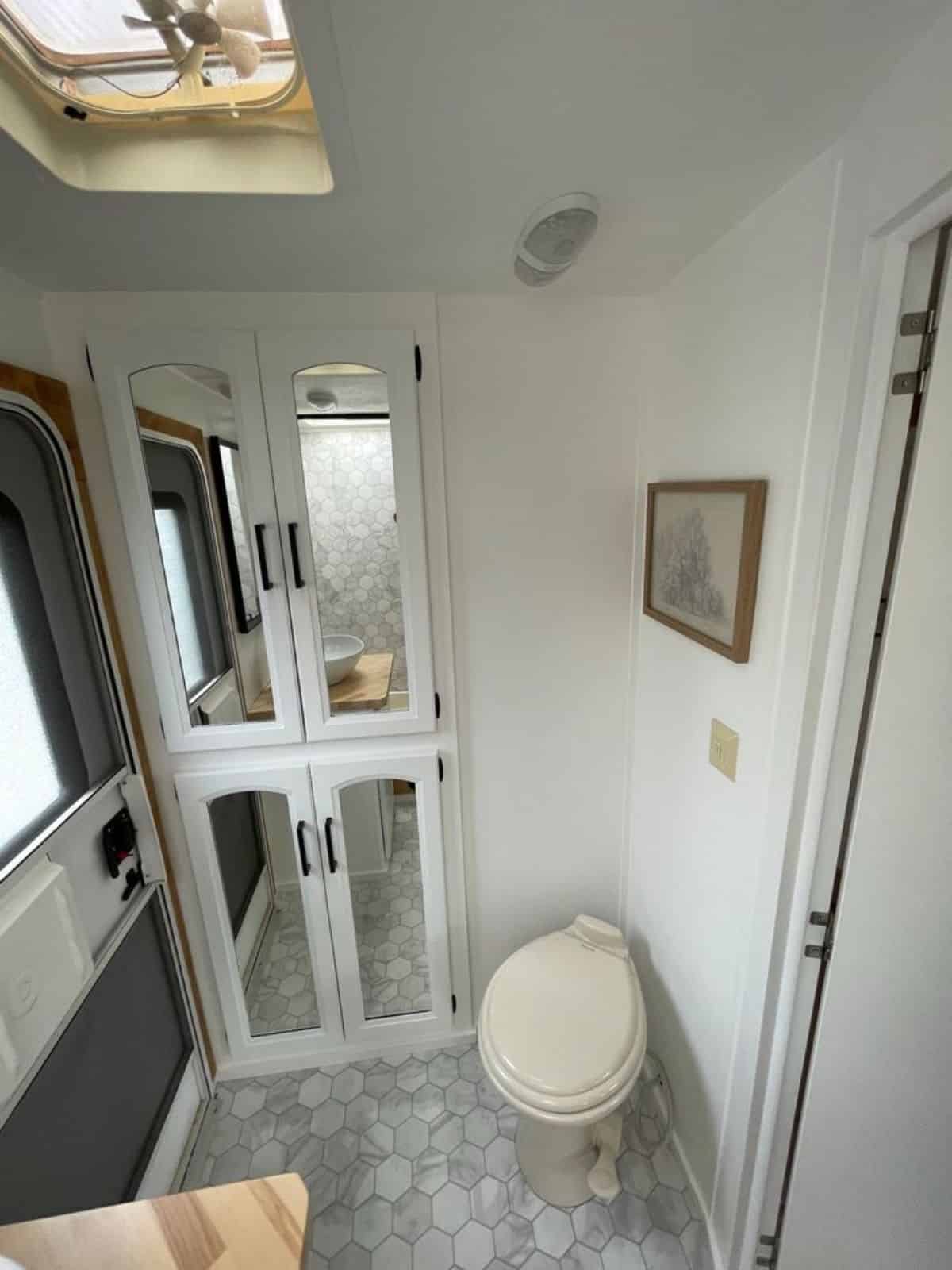 double door storage for all toiletries and standard toilet in bathroom