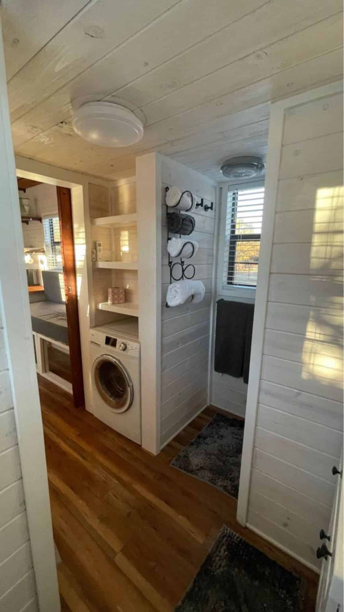 washer dryer combo with storage cabinets and towel racks in bathroom