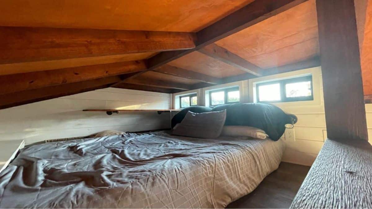loft bedroom has a comfortable couch with multiple windows