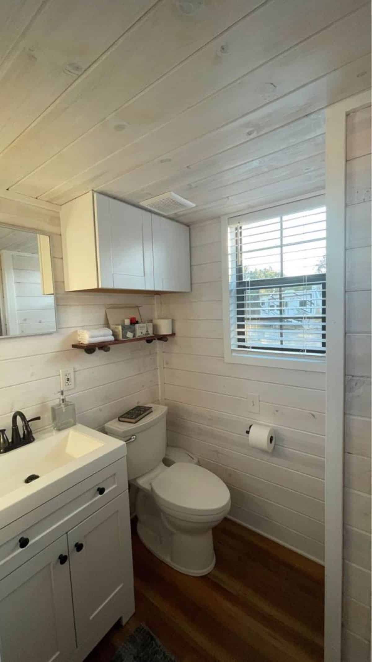 standard toilet in bathroom of tiny home for four