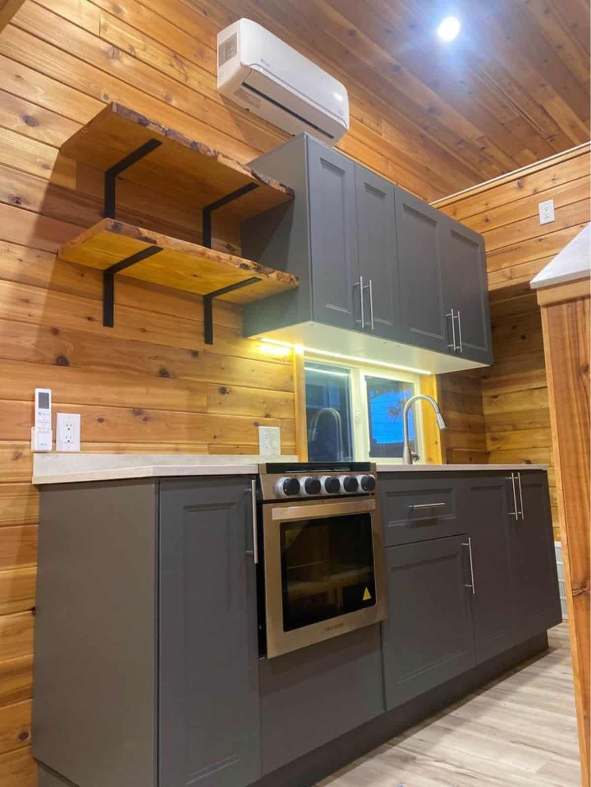 full length modern grey rustic theme kitchen with an air condition unit of double lofted tiny home