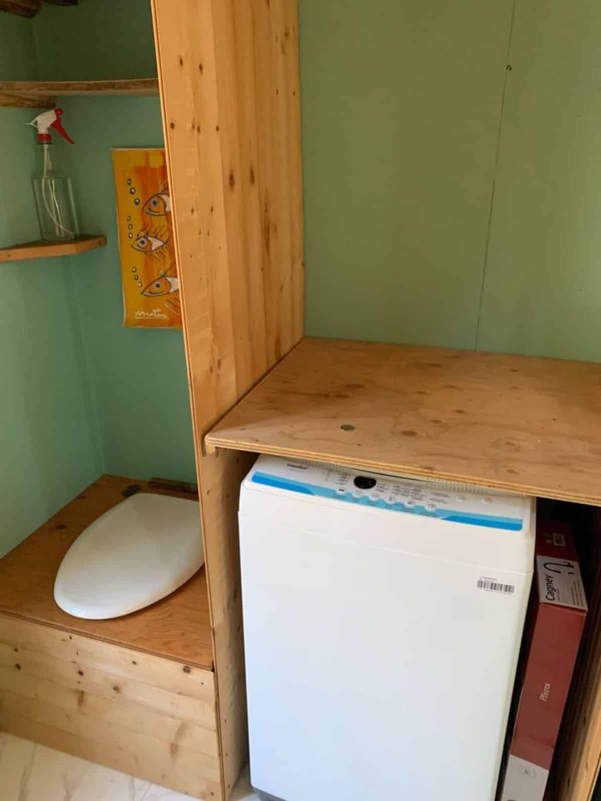 composting toilet and washer dryer in bathroom of rustic 28’ tiny home