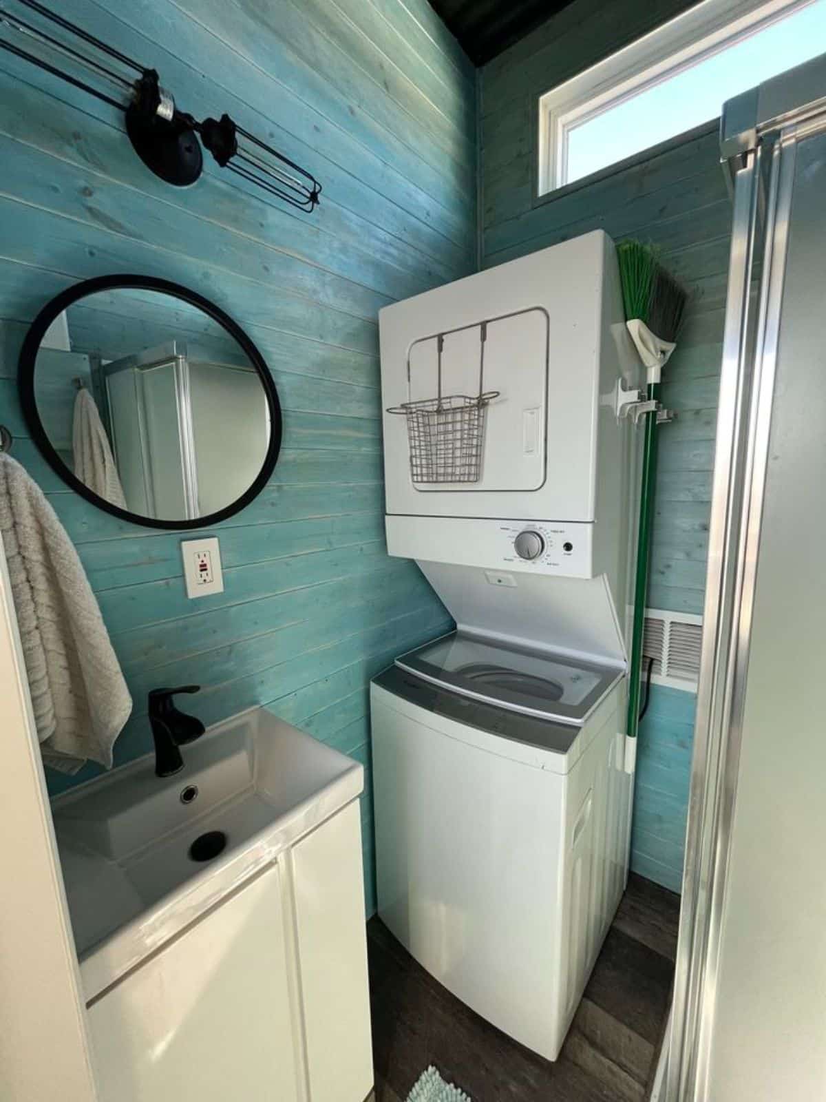 bathroom of 35’ tiny home has all the standard fittings with stackable washer dryer combo
