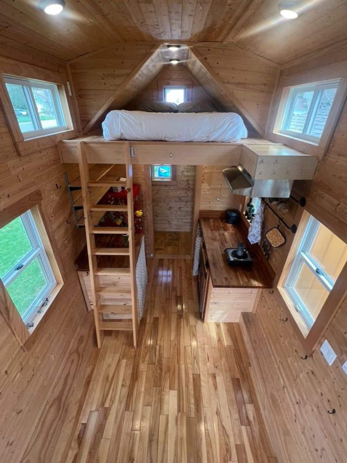 full length interior with wooden walls and wooden flooring of 20’ compact tiny home