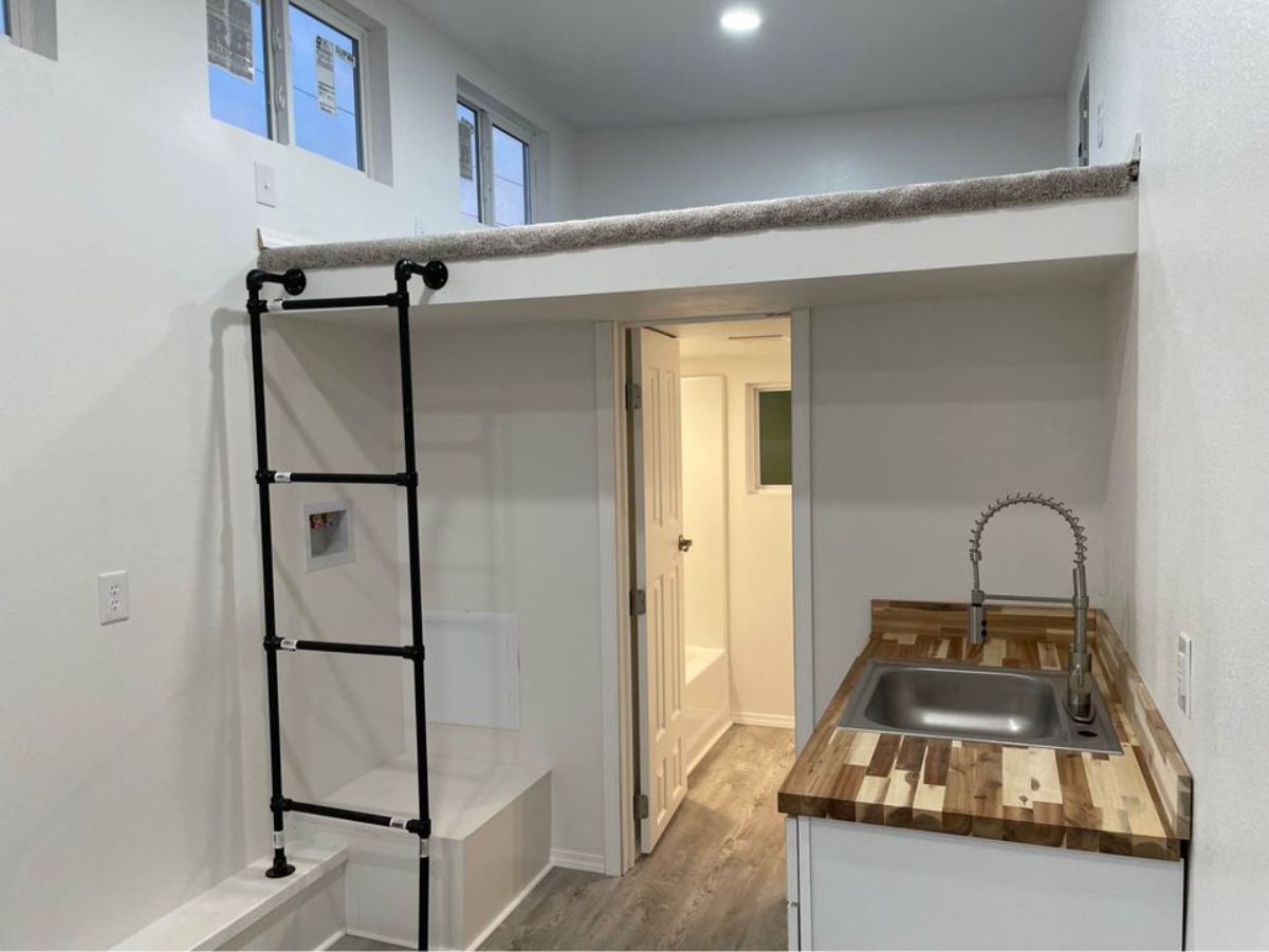compact kitchen area with ladder towards the loft bedroom