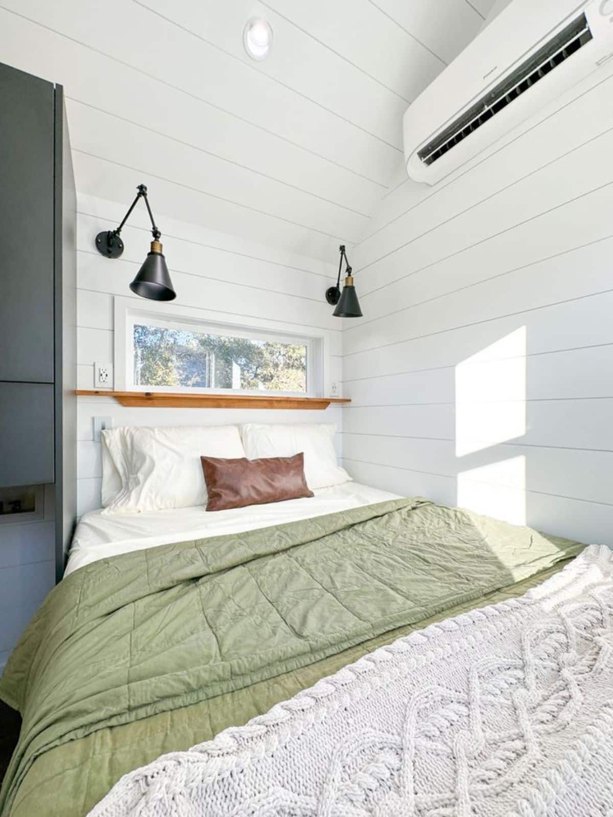 bedroom of Jojo Bean has a comfortable bed, wall mounted air condition unit