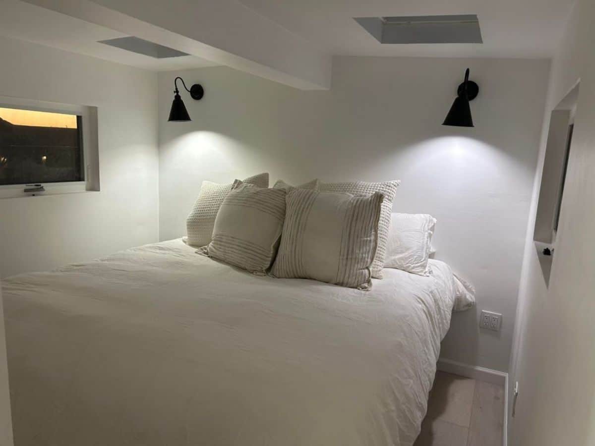 bedroom has a comfortable bed, night lamps and still has an ample space