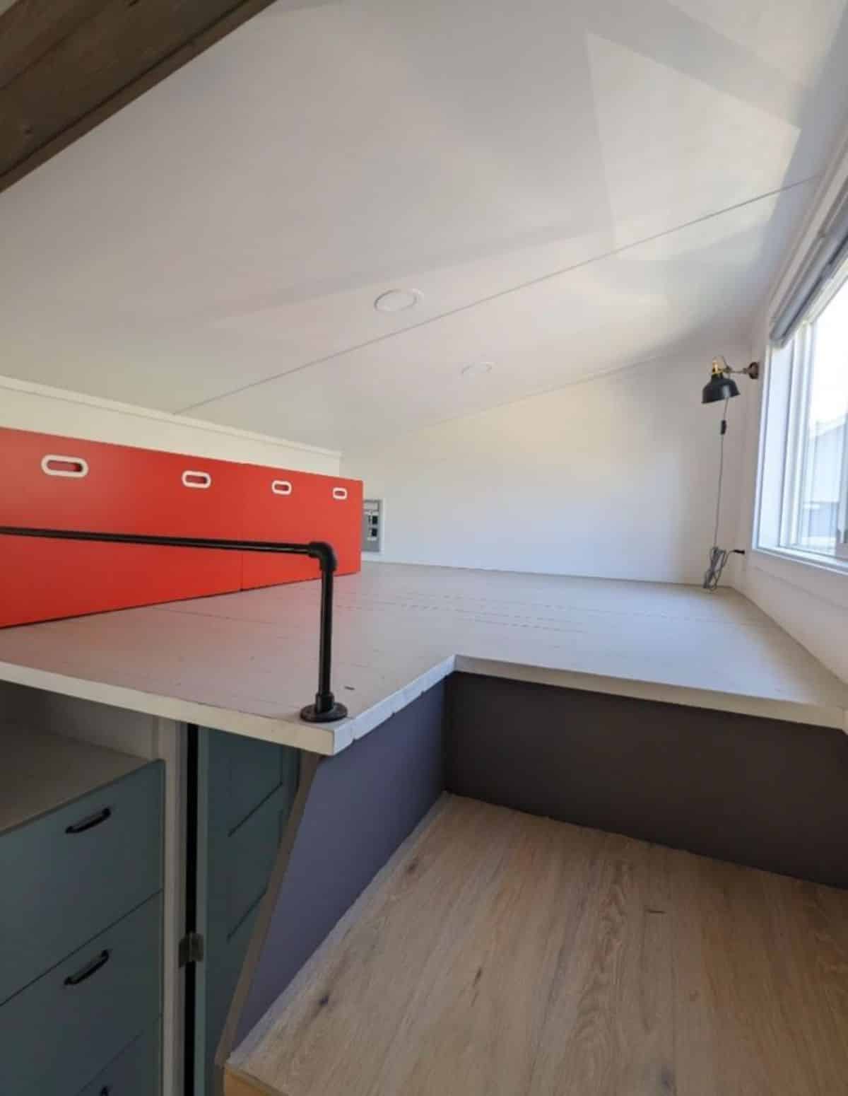 loft bedroom of three bedroom tiny house is huge with storage cabinets