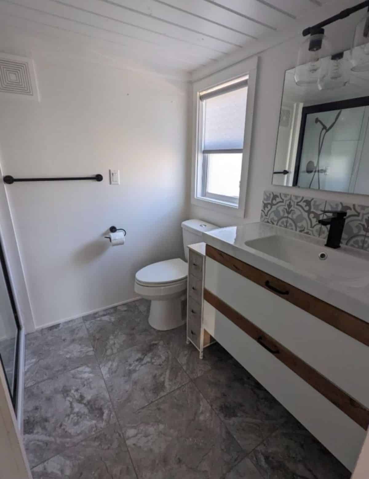 bathroom of three bedroom tiny house has all the standard fitting with ample space left to move
