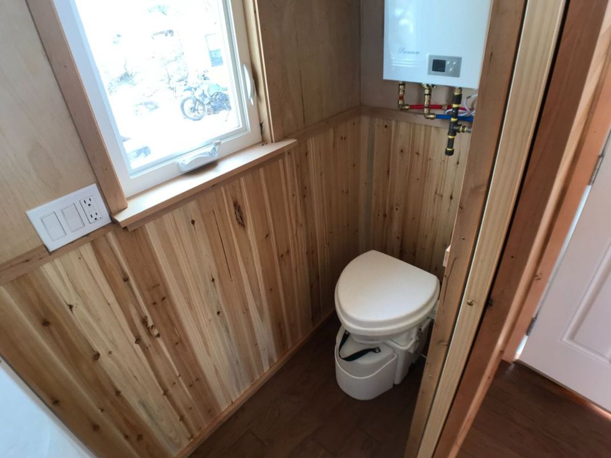 composting toilet installed in bathroom with separate shower area