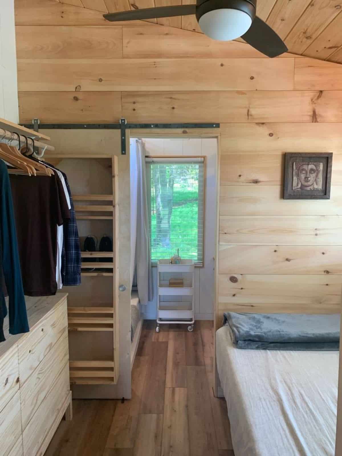 shoe rack and closet in bedroom of 28’ custom tiny home