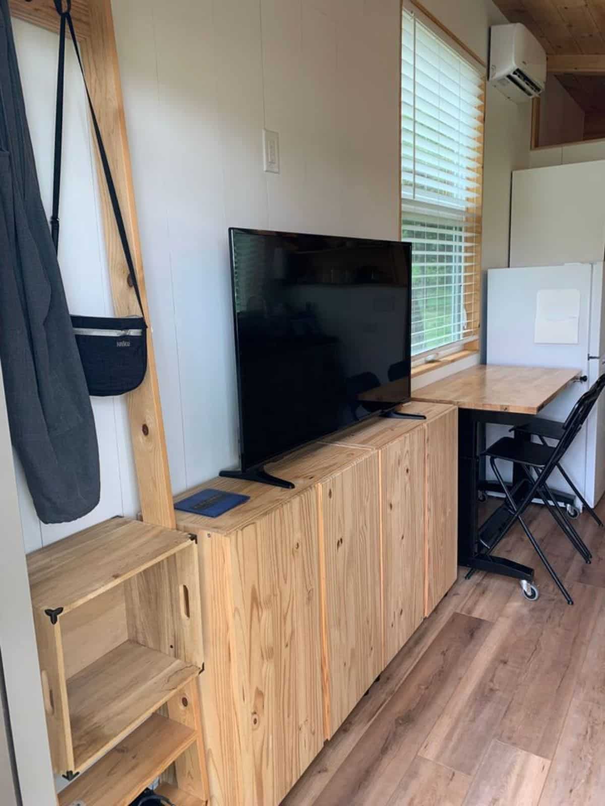 entertainment unit in living area of 28’ custom tiny home