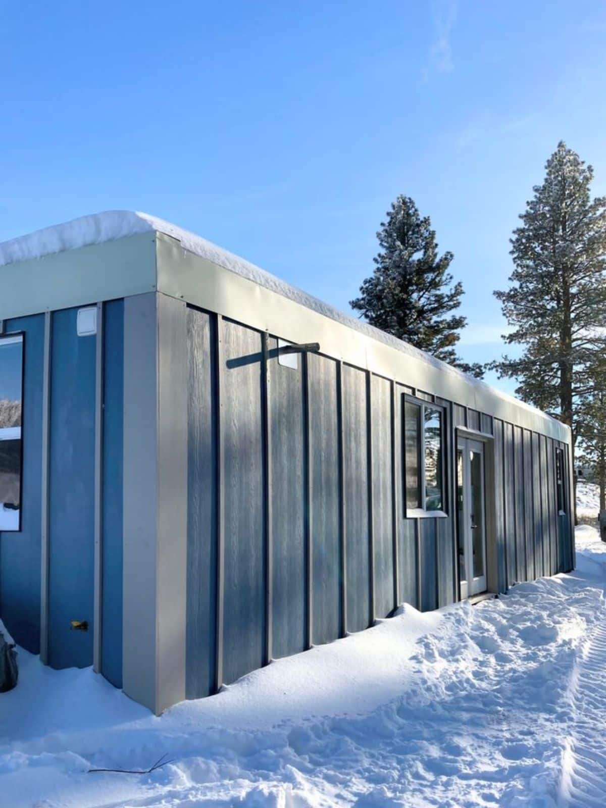 main entrance view of 40’ custom tiny home under snow