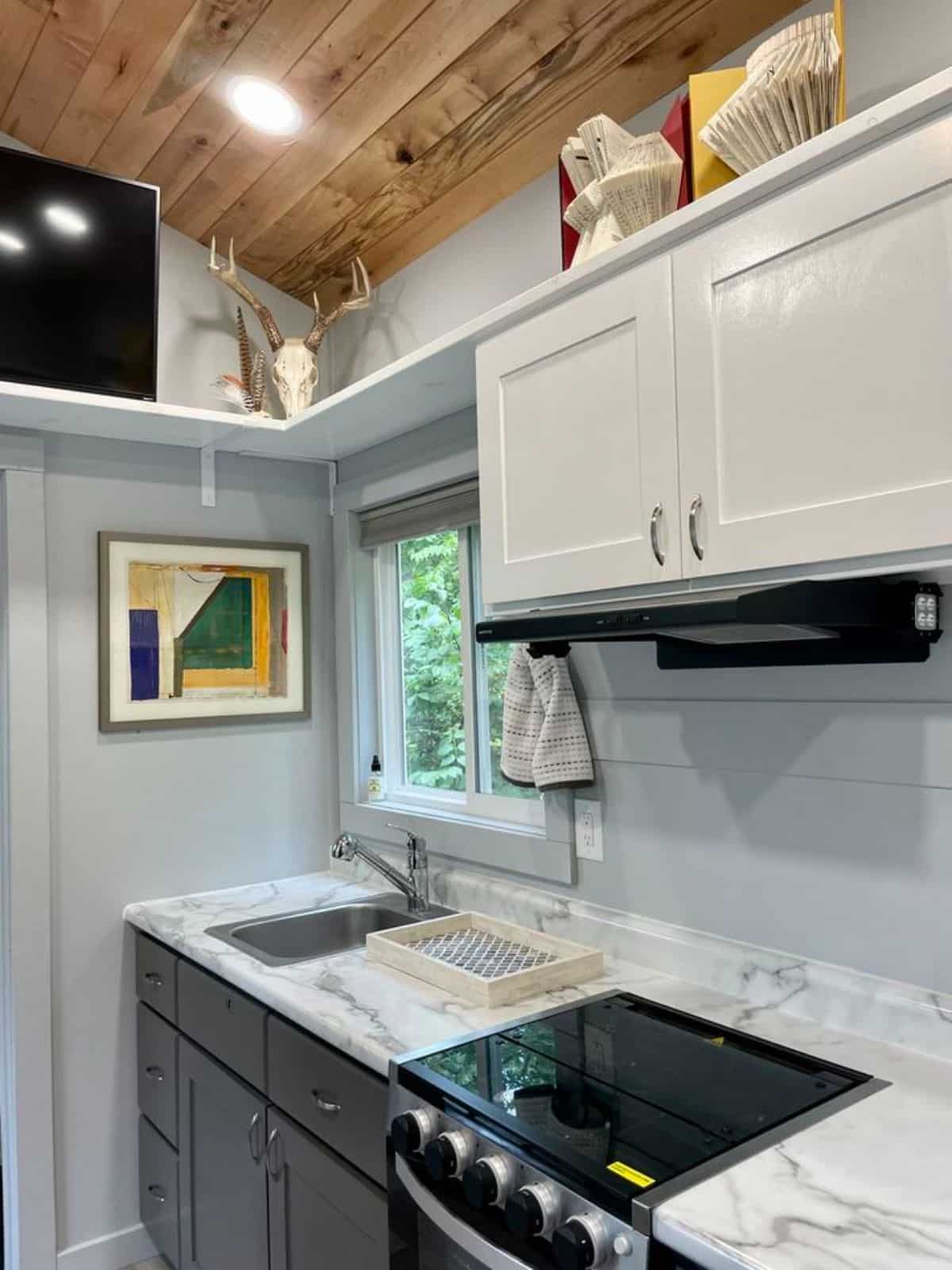 shelves and storage cabinets above the kitchen countertop of high end tiny home