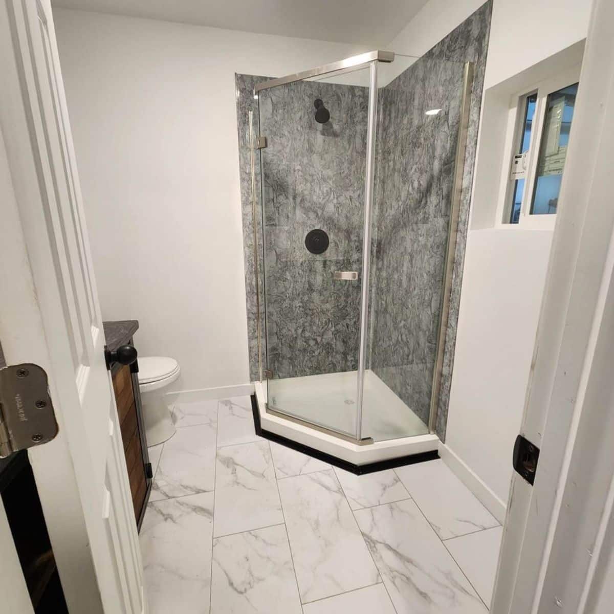 full length shower area with glass enclosure in bathroom of beautiful container home