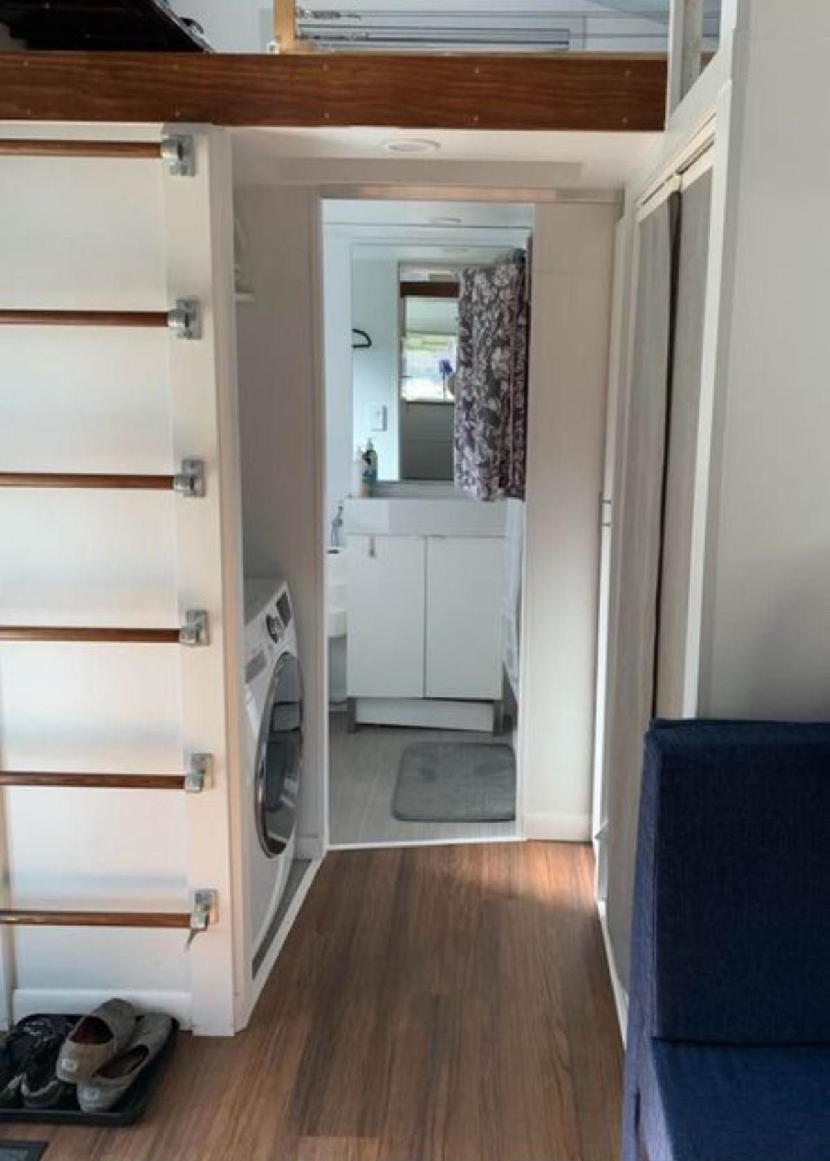 separate place for washer dryer combo at the bathroom door of beautiful tiny home