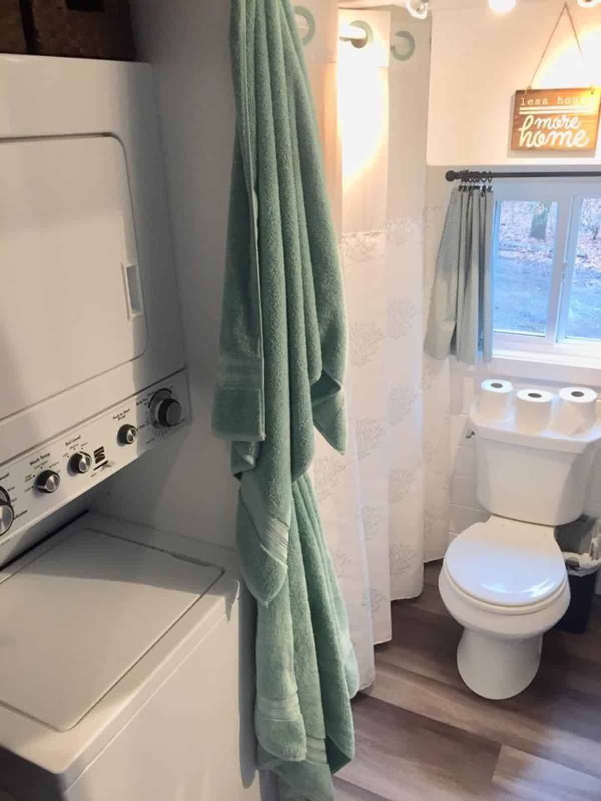 standard toilet and washer dryer combo in bathroom