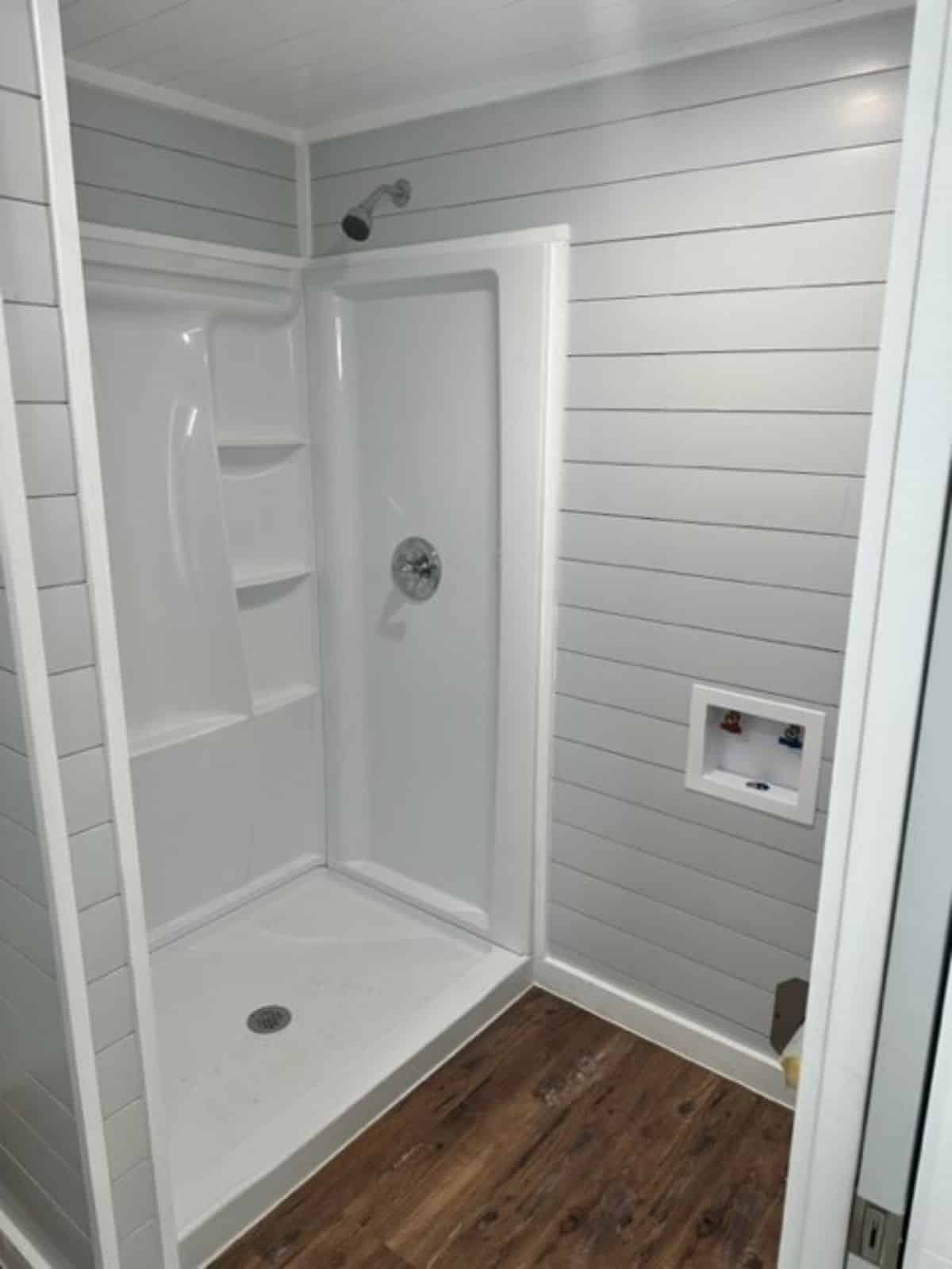 bathroom has all the standard fittings and long shower area