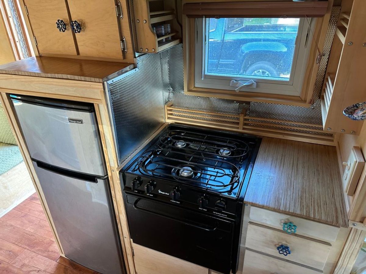 propane gas stove oven and refrigerator with storage on 1 side of the kitchen